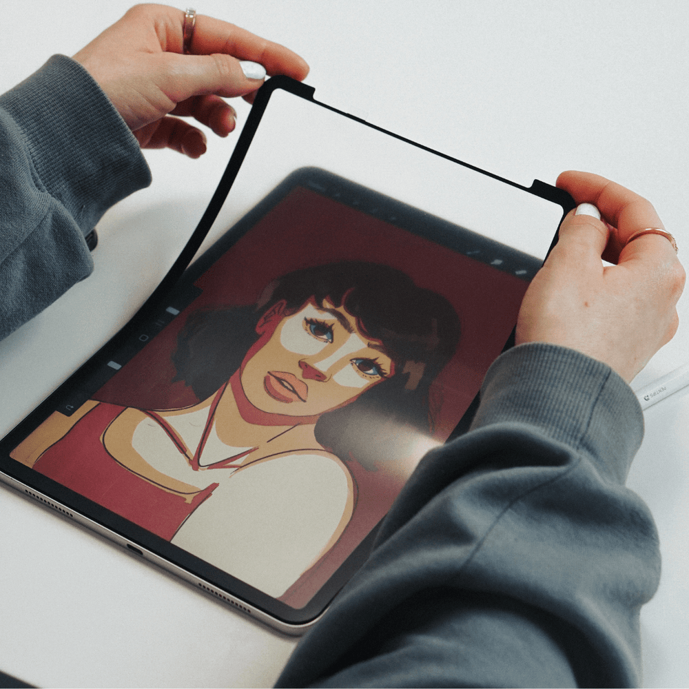 Person holding tablet with digital drawing of a woman in a red top.